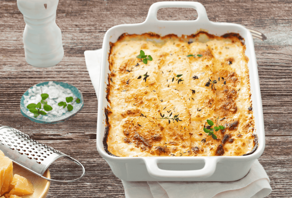 A close-up of a cheesy potato casserole with a golden, bubbly top.