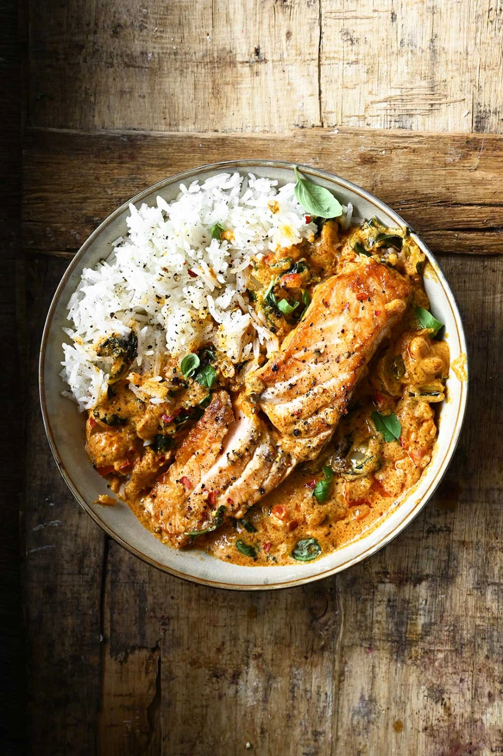 Microwave Red Curry Poached Salmon served with rice, garnished with fresh cilantro and lime wedges in a glass bowl