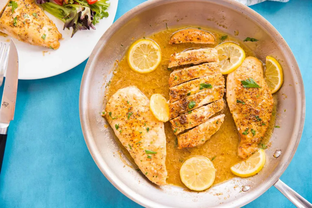 Pan-fried Lemon Pepper Chicken Breasts with fresh parsley garnish and lemon slices